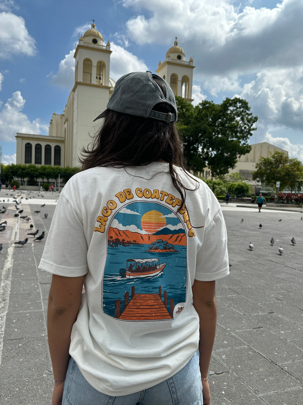 Woman wearing Lago de Coatepeque tee at the cathedral plaza in San Salvador