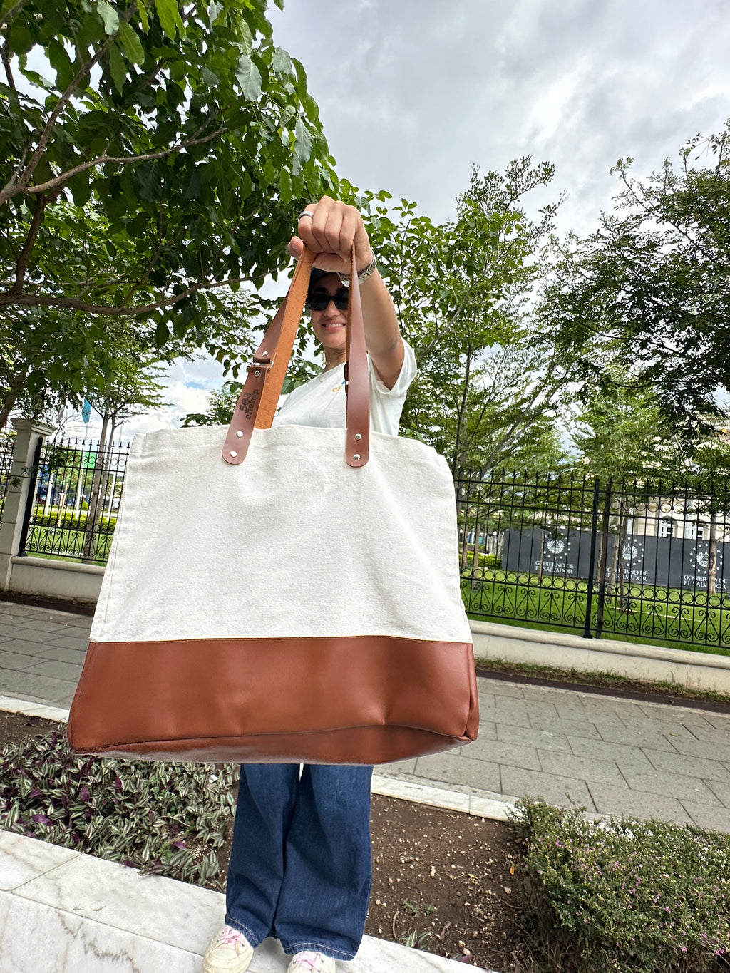 Woman holding 503Cher@s Medium Tote Bag outdoors showing full size and leather handles